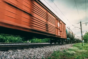 A fast-moving freight train with container and tanker cars.